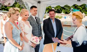 Ślub cywilny nad jeziorem: para młoda, świadkowie i urzędniczka w przyłbicy.
