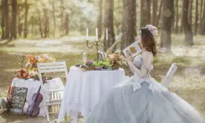 Panna młoda w lesie, z książką o tym, od czego zacząć przygotowania do ślubu. Romantyczna sceneria z kwiatami i skrzypcami.