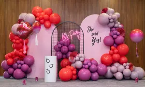 Girlanda z różowych i czerwonych balonów, neonowy napis "Let's Party" i napis "She said Yes!".